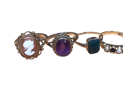 Lot 189 - Five gold rings to include a 9ct gold cameo ring in open work setting, 9ct gold oval amethyst, 9ct gold bloodstone plaque, 9ct sapphire and seed pearl seven stone ring and a blue stone yellow metal...