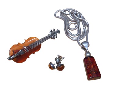 Lot 195 - Silver mounted amber brooch in the form of a violin, silver mounted amber pendant on chain and a pair of silver mounted amber stud earrings