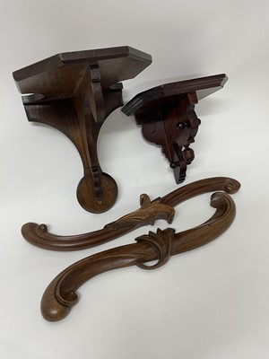 Lot 532 - Edwardian oak wall bracket, together with another mahogany example and two late 19th century mahogany scroll mounts (4)