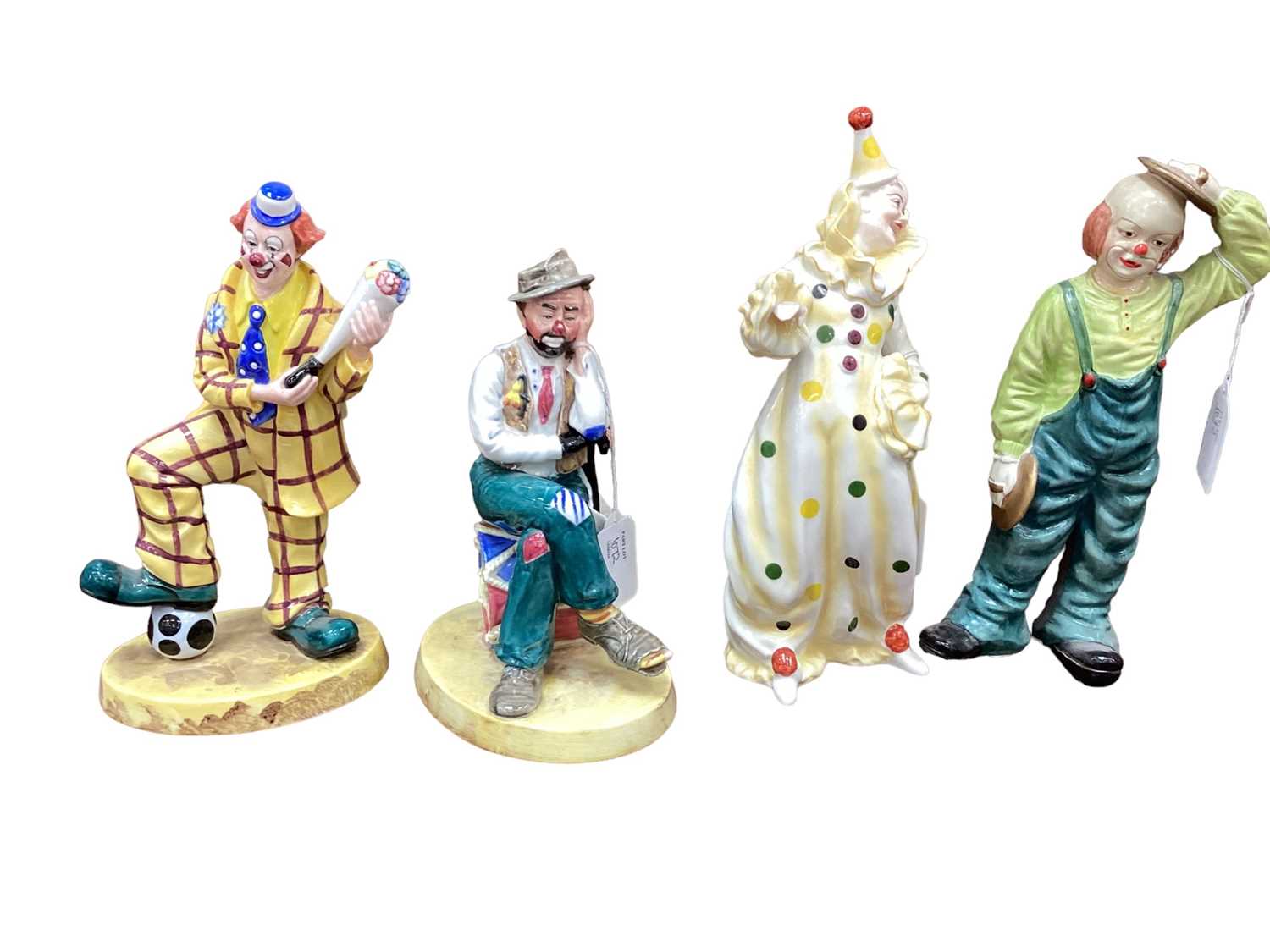 Lot 1072 - Three Coalport Clowns including Woeful Tramp and Auguste's Bouquet, together with an unmarked clown (4)