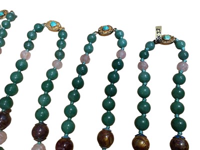 Lot 130 - Six Chinese green hard stone, carnelian and carved rose quartz bead necklaces with silver gilt claps set with a turquoise stone