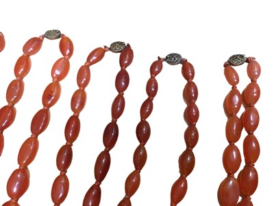 Lot 131 - Six Chinese oval carnelian bead necklaces with silver gilt clasps