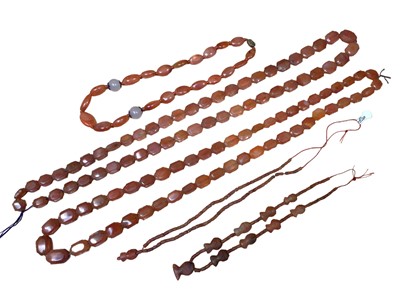 Lot 132 - Two long carnelian lozenge shaped bead necklaces, two carnelian carved fish bead necklaces and one other carnelian polished bead necklace with silver gilt clasp (5)