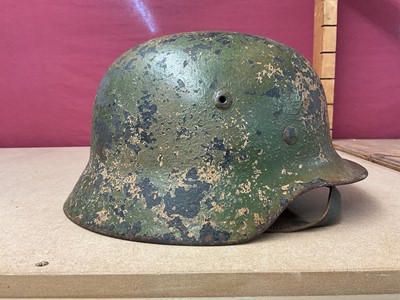 Lot 785 - Second World War Nazi German M35 pattern Luftwaffe steel helmet, with camouflage painted exterior, with chinstrap and liner, the liner inscribed Peter Schnitzhofer. N.B. we believe he was a P.O.W....