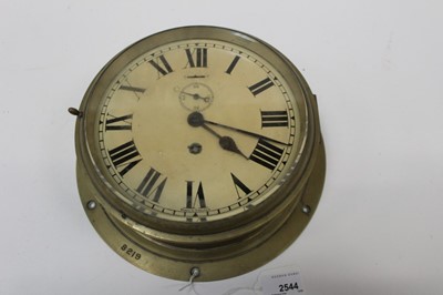 Lot 2544 - A brass bulkhead clock, white enamel dial, the case 27cm diameter and stamped '8219'