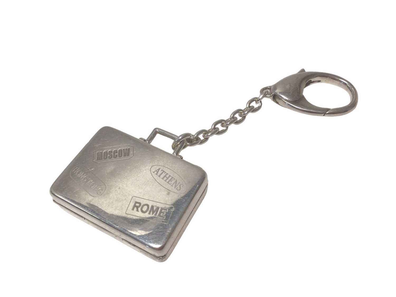 Lot 107 - Asprey silver suitcase key ring with engraved travel labels (London, 2007)