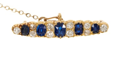 Lot 614 - Victorian sapphire and diamond bar brooch with five oval mixed cut blue sapphires interspaced by old cut diamonds in gold setting, 32mm.