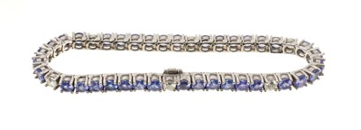 Lot 616 - Tanzanite and diamond tennis bracelet with 37 round tanzanites totalling 9.37cts interspaced by 6 round brilliant cut diamonds totalling 1.25cts, all in 14ct white gold setting retailed by Charles...