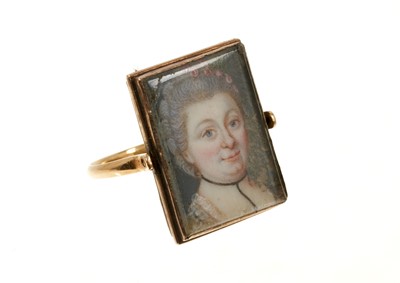 Lot 651 - A rare George III double portrait ring with a double-sided revolving bezel containing two portrait miniatures on ivory depicting a lady and a gentleman, on a plain gold shank.