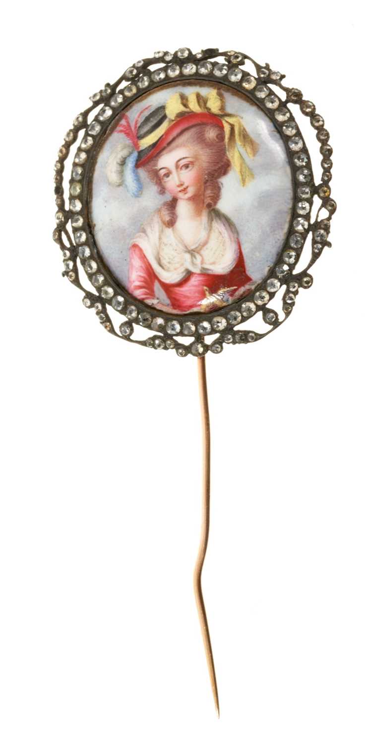 Lot 655 - 18th century enamel portrait miniature depicting a lady holding a bird, the oval enamel panel within a frame set with rose cut brilliants in silver with gold back, later stick pin fitting. The fram...