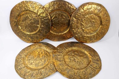 Lot 1022 - Five 19th century Indian circular brass temple plates decorated in relief with Gods and figures, 42cm diameter