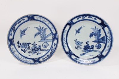 Lot 348 - Pair of 18th century Chinese blue and white porcelain dishes, decorated with birds and flowers in a garden, the outside with foliate panels, 32cm diameter