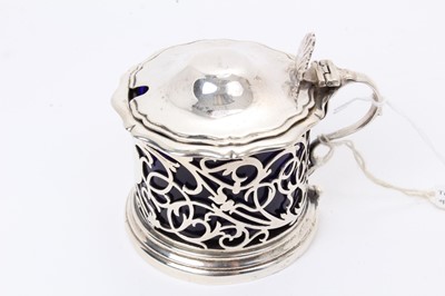 Lot 419 - Late Victorian silver mustard of circular form, with pierced decoration and hinged domed cover, with shell thumbpiece, blue glass liner (Sheffield 1901) Henry Atkins. All at approximately 3ozs. 7.5...