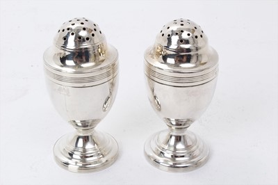 Lot 412 - Pair George III silver pepper pots of urn form with pierced slip on covers