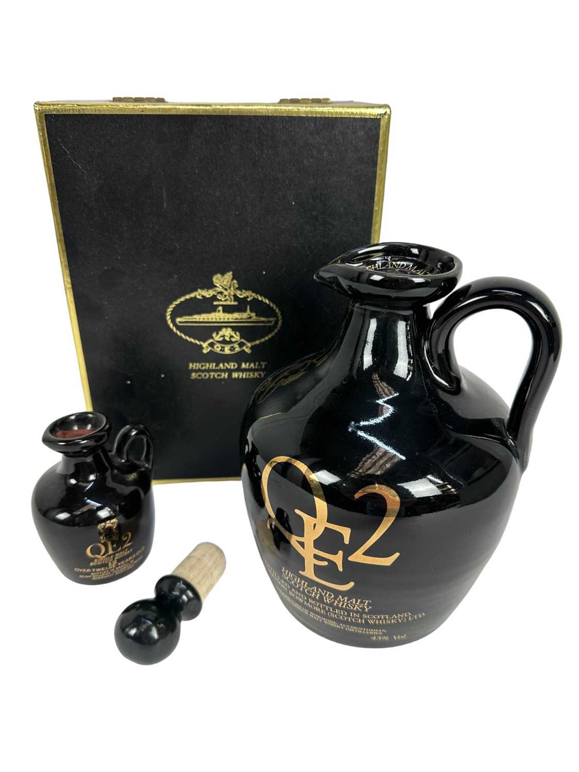 Lot 28 - Whisky - two bottles, QE2 Highland Malt Scotch Whisky 75cl ceramic flagon 43%, in presentation box, together with a miniature version (2)