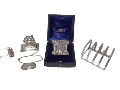 Lot 22 - Group of silver, including an Edwardian Mappin & Webb ship-form menu holder, a George V teddy bear, a Victorian Madeira label, a George V toast rack and a heavy cased Victorian napkin ring (5)