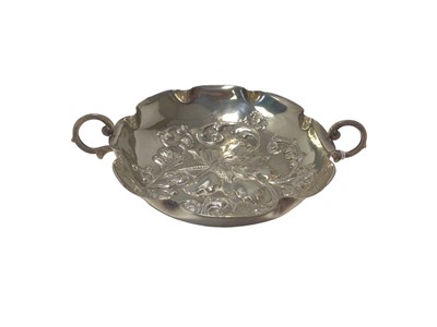 Lot 38 - Silver twin-handled bowl, probably American, of foliate form with flower decoration in relief, marked 'Sterling' and 'K.T.' with another illegible mark, 13.5cm wide, 2.8oz