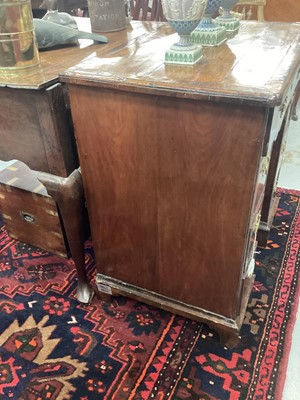 Lot 1055 - George II walnut and crossbanded and featherbanded kneehole desk, the top with re-entrant angles, having seven drawers and shaped frieze drawer about the cupboard kneehole on bracket feet, 69cm wid...