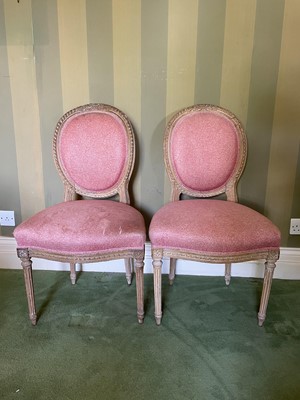 Lot 1138 - Pair of 19th century Continental limed beech upholstered side chairs, in the Louis XVI style, each with ribbon carved show wood frame and pad back and seat on fluted legs