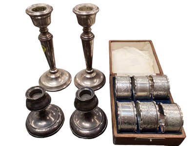 Lot 1091 - Set of six silver napkin rings in fitted wooden case and two pairs of silver candlesticks