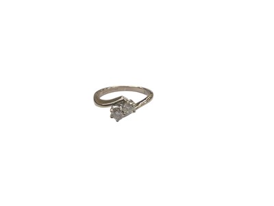 Lot 1095 - 18ct white gold diamond two stone cross over ring