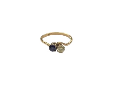 Lot 1096 - 18ct gold sapphire and diamond (yellow tint) two stone cross over ring