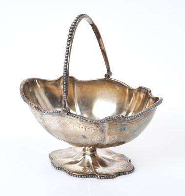 Lot 157 - Victorian silver swing handled sugar basket of shaped oval form, with engraved foliate decoration