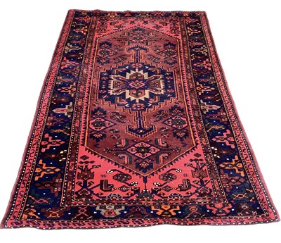 Lot 1422 - Eastern rug with geometric decoration on red and blue ground, 235cm x 139cm