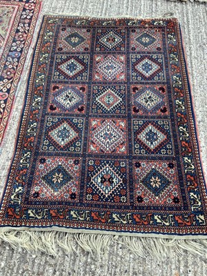 Lot 1340 - Eastern rug decorated with 15 medallions on red and blue ground, 151cm x 103cm