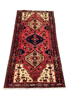 Lot 1406 - Eastern rug with three central medallions on red blue and cream ground, 197cm x 102cm