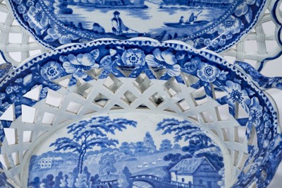 Lot 6 - Pair of 19th century pearlware chestnut baskets and stands, printed in blue and white with landscapes, the stands measuring 27.5cm wide