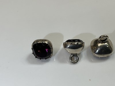 Lot 369 - Seven Georgian foil-backed silver and amethyst paste buttons with collet setting, circa 1800.