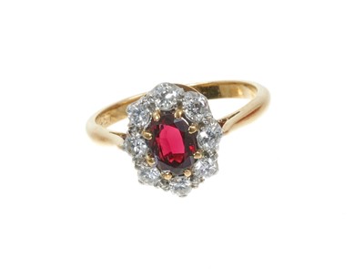 Lot 313 - Garnet and diamond cluster ring with an oval mixed cut garnet surrounded by 
eight brilliant cut diamonds in platinum claw setting 18ct yellow gold shank