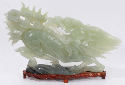 Lot 631 - Large Chinese jade or green hardstone carving of a mythical beast, raised on wooden plinth, 43cm long