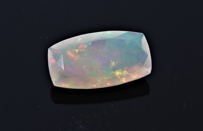 Lot 403 - Unmounted natural opal weighing 4.56cts, the rectangular cushion shape fancy-cut stone measuring 17.38mm x 9.68mm x 5.40mm, accompanied by a Gem certificate from The Gem and Jewellery Institute of...