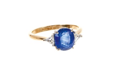 Lot 472 - Sapphire and diamond ring with a cushion cut blue sapphire flanked by two triangular diamonds