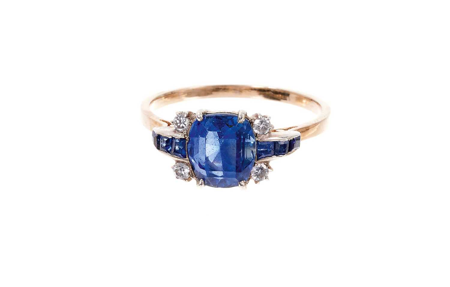 Lot 400 - Art Deco sapphire and diamond ring with a cushion shape mixed cut blue sapphire flanked by four diamonds and calibre cut blue sapphires to the tapered shoulders