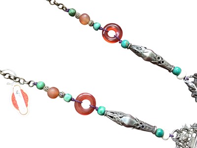 Lot 2 - Old Chinese white metal necklace with pierced floral scroll panels, carved coral and turquoise drops suspended from chains and further beads interspaced on the chain.