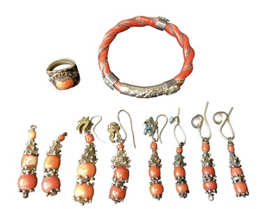 Lot 3 - Old Chinese coral carved rope twist bangle with white metal mounts, a similar coral ring and four pairs of coral drop earrings