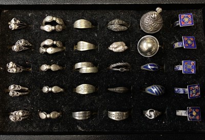 Lot 10 - Collection of Eastern silver and white metal rings including some with enamelled decoration, within a ring display tray