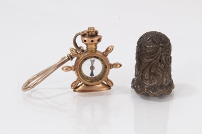 Lot 528 - Late 19th century 10ct gold fob in the form of a compass mounted in a ship's wheel (underside stamped Rd No 6143 with a cross and 10), together with a white metal thimble. (2)