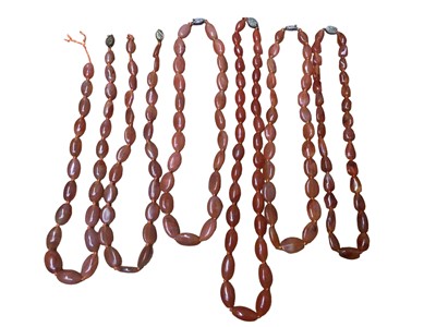 Lot 13 - Six Chinese oval carnelian bead necklaces with silver clasps, 65cm - 52cm long