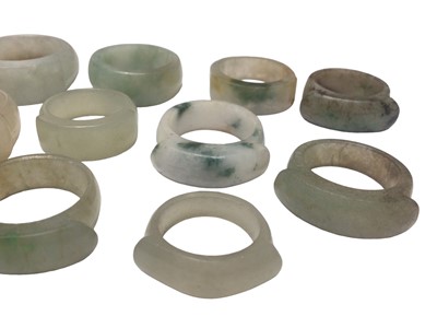 Lot 17 - Collection of twelve Chinese polished green hard stone/ jade rings