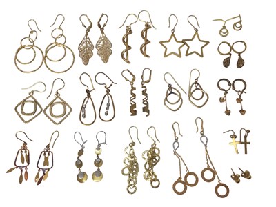 Lot 99 - Seventeen pairs of 9ct gold drop earrings including stars, crosses, hoops, discs etc   
24.4g