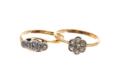 Lot 409 - Two early 20th century 18ct gold and diamond rings to include a daisy cluster with seven old cut diamonds, together with a three stone diamond ring