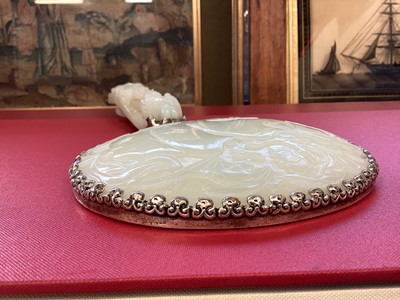 Lot 721 - Chinese jade and white metal hand mirror, stamped HK, the oval mirrored plate with convex jade plaque to the rear, carved in low relief with fruit, flowers and a bat, 25cm long, probably comprising...