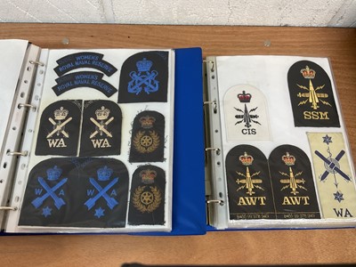 Lot 759 - Two albums of cloth Royal Navy badges and insignia to include cap tallies (2 albums)