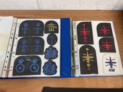 Lot 759 - Two albums of cloth Royal Navy badges and insignia to include cap tallies (2 albums)