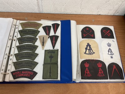 Lot 759 - Two albums of cloth Royal Navy badges and insignia to include cap tallies (2 albums)