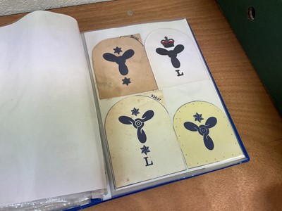 Lot 759 - Two albums of cloth Royal Navy badges and insignia to include cap tallies (2 albums)